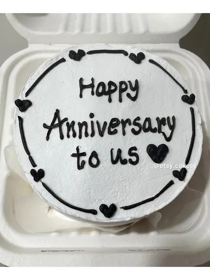 A classic black and white anniversary bento cake with a heart border.