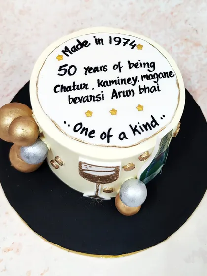 We raise a glass to a milestone birthday with this vintage champagne cake. Featuring a Moët bottle, a painted wine glass, and a personalized message, this cake is accented with gold and silver spheres for a celebratory and refined design.