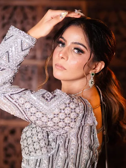 A close-up portrait showing how the outfit pairs with glamorous makeup. The emerald earrings add a beautiful pop of color.