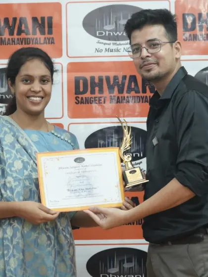 A teacher presents an award to his adult student.