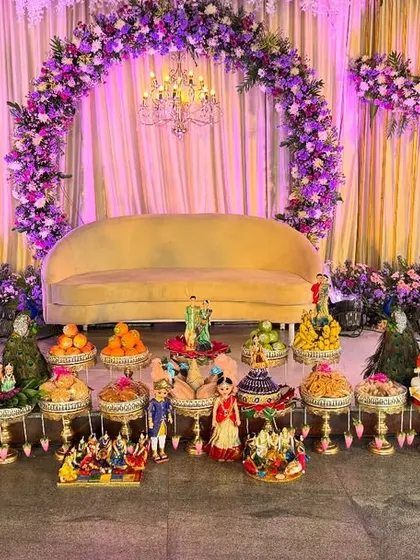 An engagement platter setup with a grand floral arch. The decorations are designed to match the purple and white color scheme, making the entire venue look spectacular.