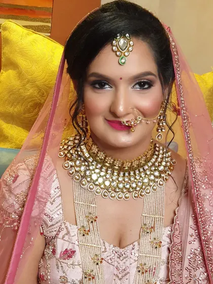 A close-up portrait of this stunning bride. Her makeup is flawless, with defined eyes, a soft pink lip, and a touch of highlighter that makes her skin glow.
