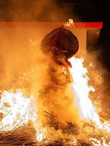 The Kandanar Kelan Theyyam, a legendary hunter, is seen here engulfed in a massive pyre. This image captures the climax of his story, where he becomes one with the fire, embodying valor and vengeance.