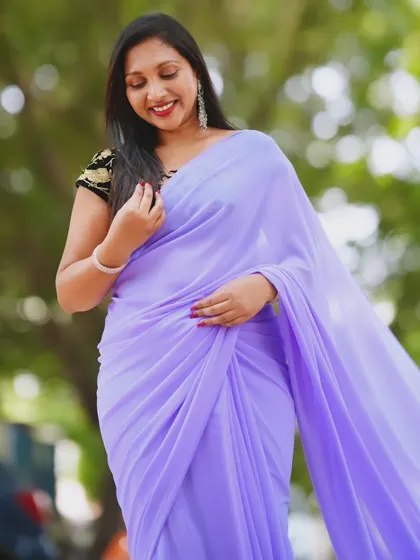 A close-up portrait showing the elegant drape of the lavender saree and the contrasting embroidered blouse.