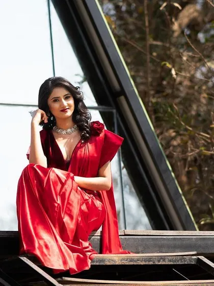 Juxtaposing the traditional red saree with modern architecture. This creates a visually interesting fusion of styles.
