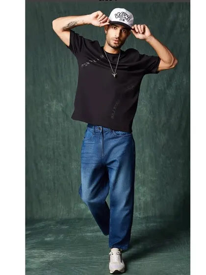 A full-length athleisure look, combining the oversized tee and cap with baggy jeans, capturing the essence of contemporary streetwear.