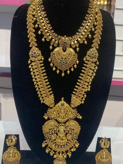 This bridal set features a unique mango-motif haram and a matching choker. It is a classic South Indian design, available for rent for your wedding.