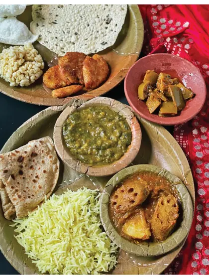 A traditional Sindhi wedding meal of Beeh Patata (Lotus Stem and Potato Curry) and Degh Waara Chanwar, served on a leaf plate. This recipe is a memory from Ulhasnagar in the 1970s.