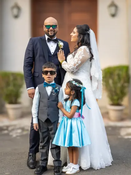 A sweet, candid moment between the couple and their little ones. Family portraits on the wedding day are all about capturing these heartwarming interactions.