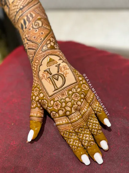 A chic and modern backhand design featuring the couple's wedding logo. This is a great way to personalize your henna while keeping the look elegant and stylish.