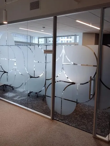 An abstract circular pattern cut from frosted film adds a unique design element to this office partition. It's a creative way to achieve privacy while adding visual interest.