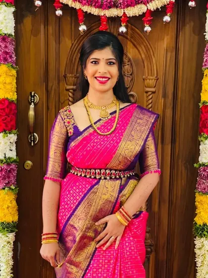 A forever favorite look for a treasured client. This vibrant pink and violet Kanchipuram silk saree is paired with a custom-designed blouse, creating a timeless and elegant ensemble for her special occasion.