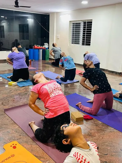 An evening class practicing Ustrasana (Camel Pose), a wonderful heart-opening posture. The calm atmosphere helps students go deeper into their practice.