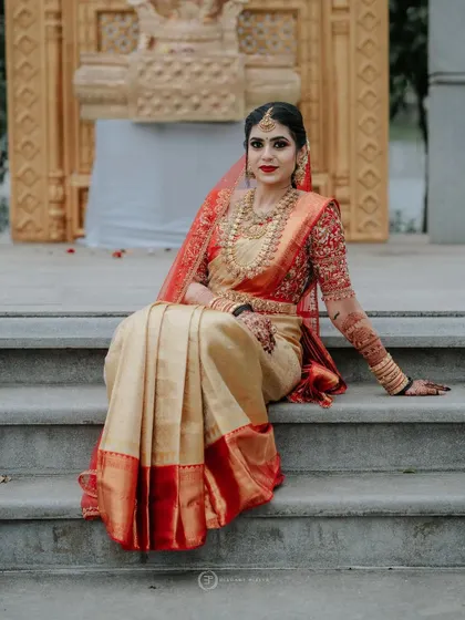 A regal portrait of the bride Arpita, her full bridal attire complemented by the deep, dark stain of her mehendi.