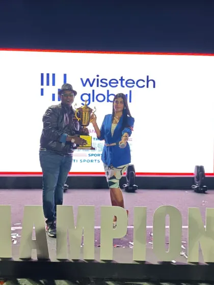 Holding the championship trophy at a corporate cricket tournament. As the event DJ, I kept the energy high for over 1,000 participants throughout the day.