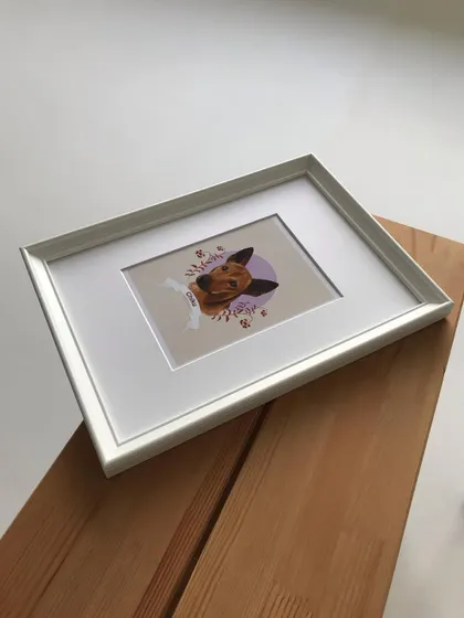 The framed Chiku portrait resting on a wooden surface. This simple, elegant presentation makes it a perfect keepsake.