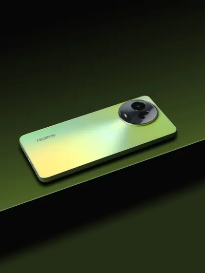 The realme C67 placed on geometric blocks with a dark green background, highlighting the phone's slim design and color gradient.