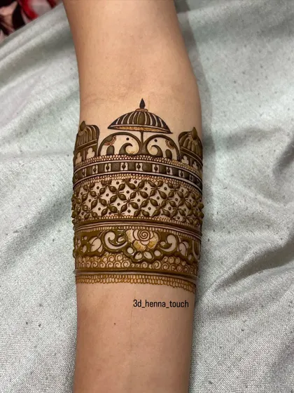 A close-up of the rose and vine details being added to the doli arm band.