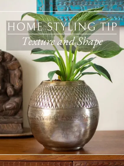 The combination of a textured metal planter and a smooth, carved statue creates a beautiful contrast. Exploring different textures is a great way to add depth to your decor.