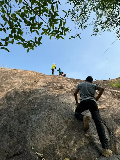 An instructor guides a young participant during a rock climbing session. Safety is paramount, and our certified team provides expert guidance for all adventure activities.