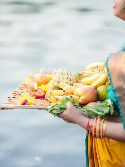 A woman holds a tray of fresh fruits as an offering during Chhath Puja. The festival is a beautiful expression of gratitude to the forces of nature that sustain us.