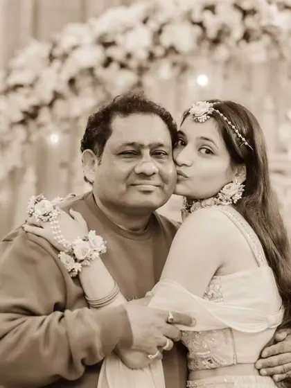 A daughter's love for her father. This sweet photo shows the bride giving her dad a kiss on the cheek during her Haldi ceremony, a tender and emotional moment.
