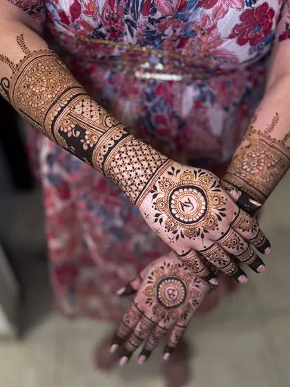 A perfect back-hand design for an engagement, featuring a central mandala with the couple's initials, "N" and "A".
