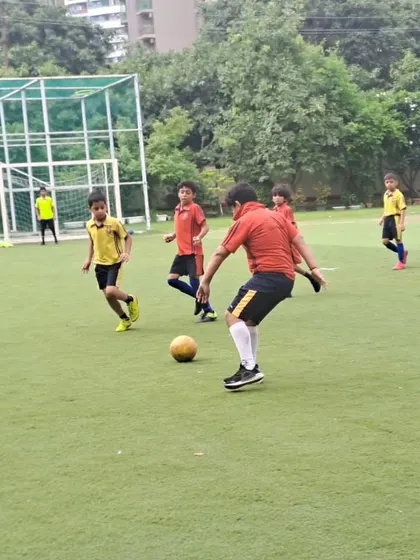 A player prepares to take a shot during the boys' football tournament. Our coaching focuses on developing fundamental skills like shooting, passing, and dribbling.