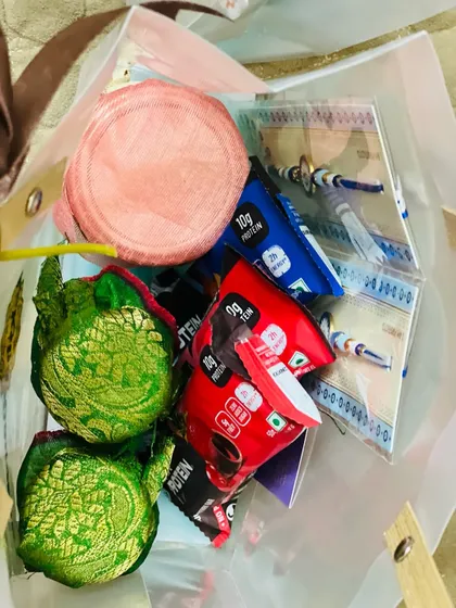 A closer look inside a Rakhi gift bag, revealing a mix of healthy snacks and traditional items.