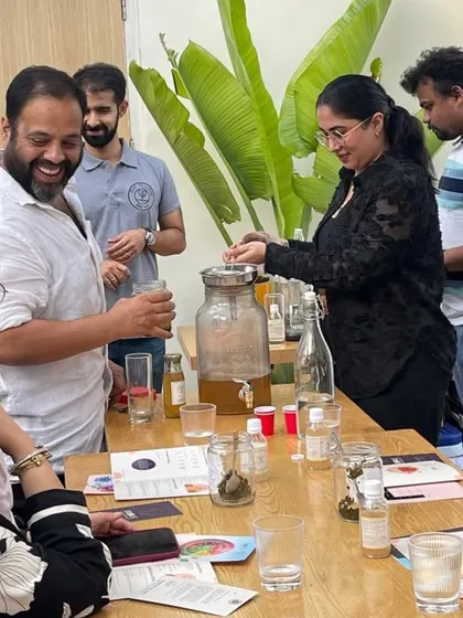 A participant gets hands-on with kombucha brewing, learning the ancient techniques behind this healthy, fermented tea. The atmosphere is full of smiles and discovery.
