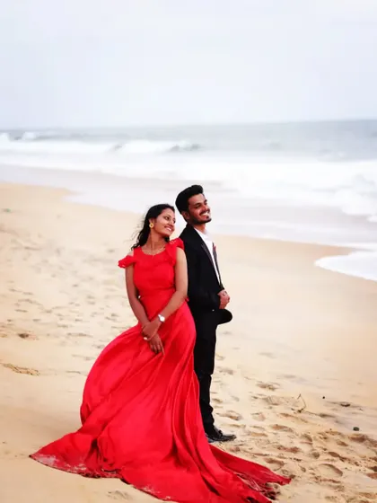 Creating memories that will last a lifetime. This couple enjoys a quiet moment on the beach, her in a simple yet elegant red gown.