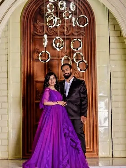 Posed against a grand doorway, this couple looks regal. Her purple gown with its delicate sleeves adds a touch of royalty to their pre-wedding photos.