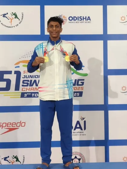 Sharan S standing proud on the podium with two of his gold medals.