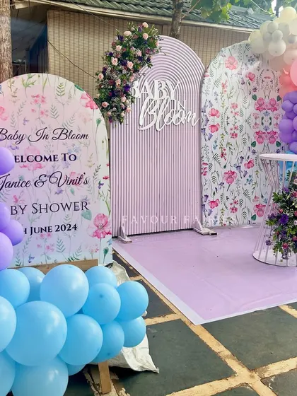 A full view of the 'Baby in Bloom' shower for Janice and Vinil. The combination of floral prints, pastel balloons, and fresh flowers creates a vibrant and joyful garden party feel.