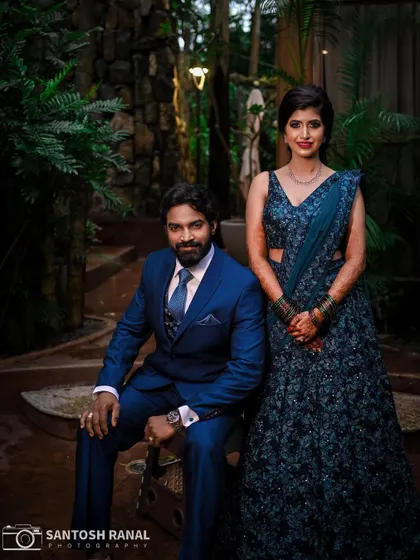 An elegant formal portrait of the couple at their reception, set in a beautiful garden location.