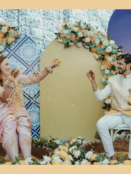 A playful moment during the Haldi ceremony, where the couple showers each other with flower petals, their laughter filling the air.