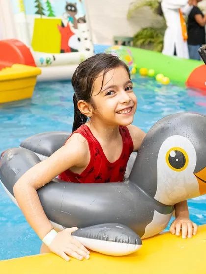 A happy memory from our last Splash Fiesta. This little swimmer is having a great time with her penguin floatie.