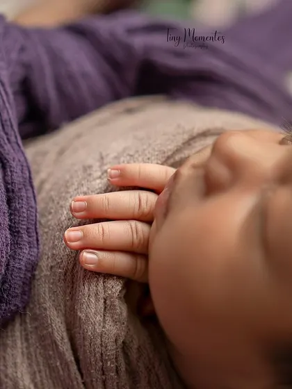 A macro shot focusing on the baby's tiny, perfect fingers resting on her chest. I love capturing these small details that you will want to remember forever.