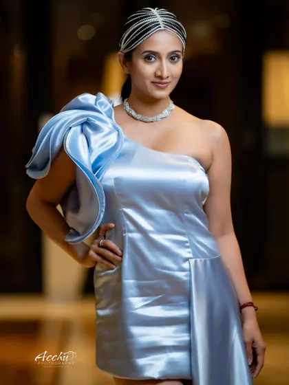 A classic portrait pose that exudes elegance. The lighting is focused on the subject's face and the unique structure of the dress, creating a timeless and polished image.