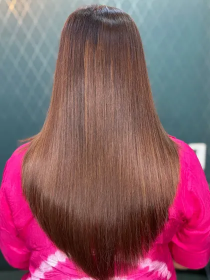 A sleek, V-cut on long brown hair. The color is low-maintenance and gives a timeless, polished look.