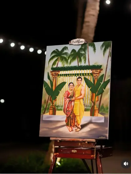 A finished live wedding painting displayed on its easel at night, under the soft glow of string lights. This piece captured a traditional South Indian wedding ceremony.