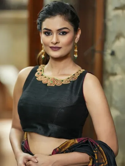 A sleeveless black raw silk blouse with a heavily hand-embroidered neckline. The intricate beadwork and stonework make it a perfect choice for a cocktail party or reception.
