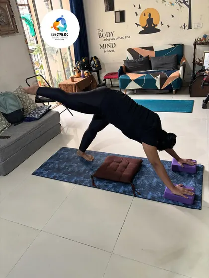 A client practices a variation of Downward-Facing Dog with a leg lift, using blocks for hand support. This builds upper body strength, opens the shoulders, and strengthens the core.