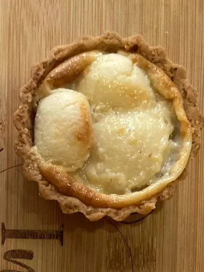 A close-up of my baked rasgulla tart. This is a unique fusion dessert, where the soft, syrupy rasgulla is baked into a creamy filling inside a crisp tart shell.