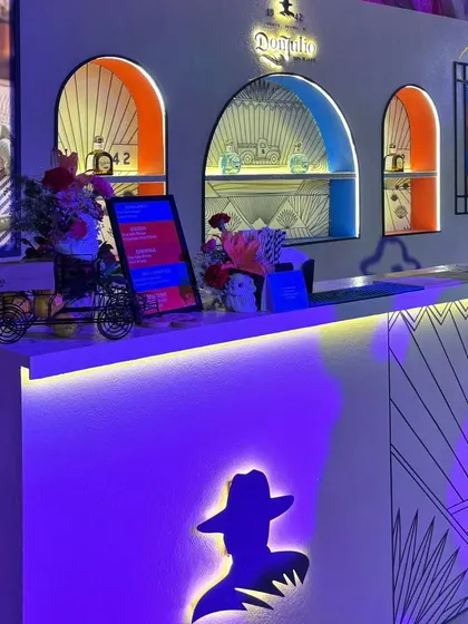 A detailed shot of the Don Julio bar, showing the thoughtful branding details like the illuminated logo silhouette, custom menus on digital screens, and themed decorative elements.