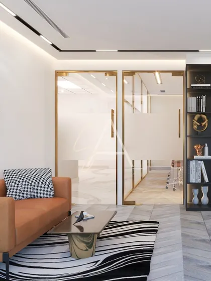 A view from the office seating area towards the main workspace. The design uses a mix of open space and glass partitions to create a dynamic and connected office environment.