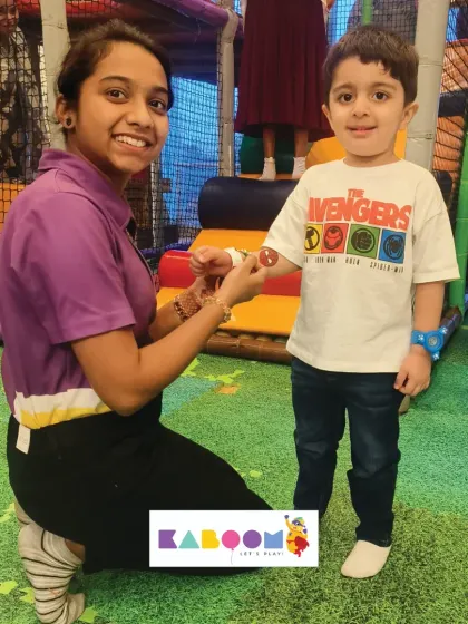 A little boy wearing an Avengers t-shirt gets his Rakhi tied by a staff member. Our events are welcoming spaces for all children to celebrate and have fun.