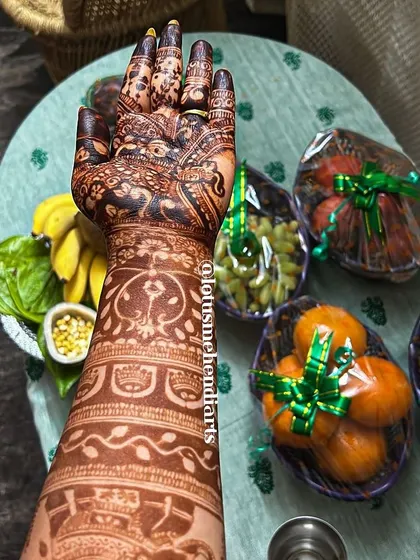 A close-up of the arm, showing the detailed patterns and the rich color of the fresh henna paste.