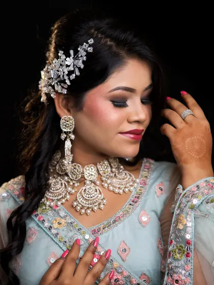 A soft and romantic engagement look created by one of our students. The pastel blue outfit, silver jewellery, and smoky eye makeup create a modern and elegant style.