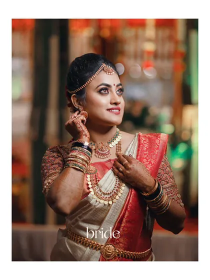 A classic and beautiful portrait of the bride, showcasing her intricate jewelry and the rich colors of her wedding saree.